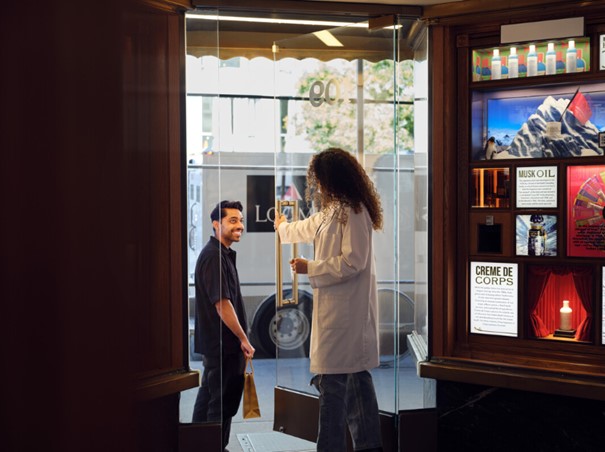 retail-worker-talking-to-a-customer-through-the-door-while-a-loomis-truck-is-parked-outside
